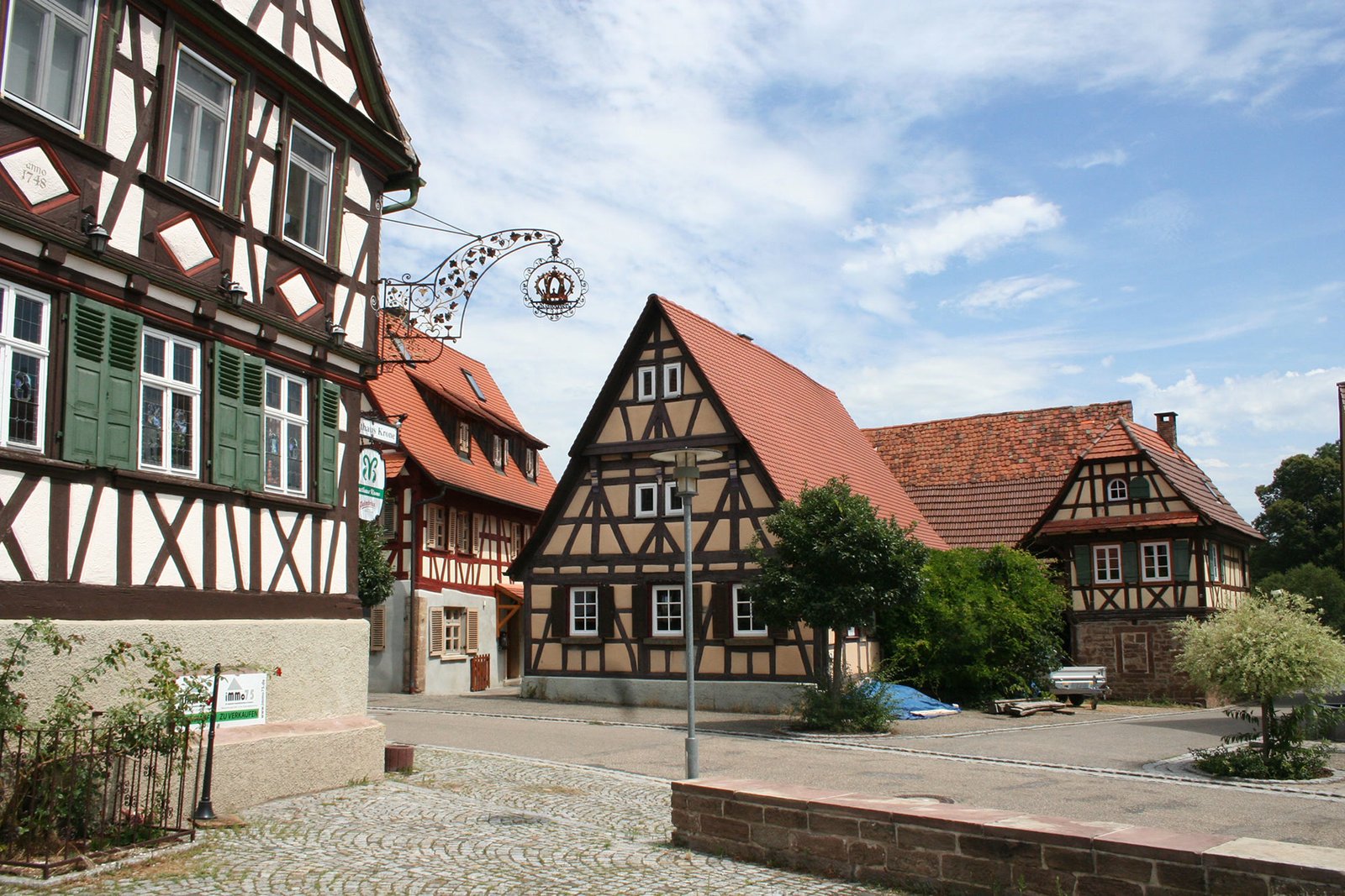Fachwerkhäuser an einer Straße im Enzkreis mit einem iMMo75 Schild